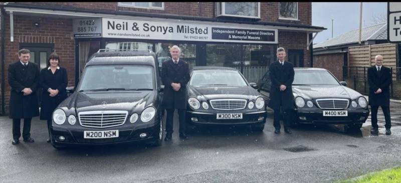 Fleet of funeral cars and funeral team